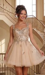 A young woman smiles in front of a grand staircase and large windows, wearing the Embroidered-Lace Short Babydoll Hoco Dress 3338 in gold, featuring a short skirt and an embroidered-lace bodice.