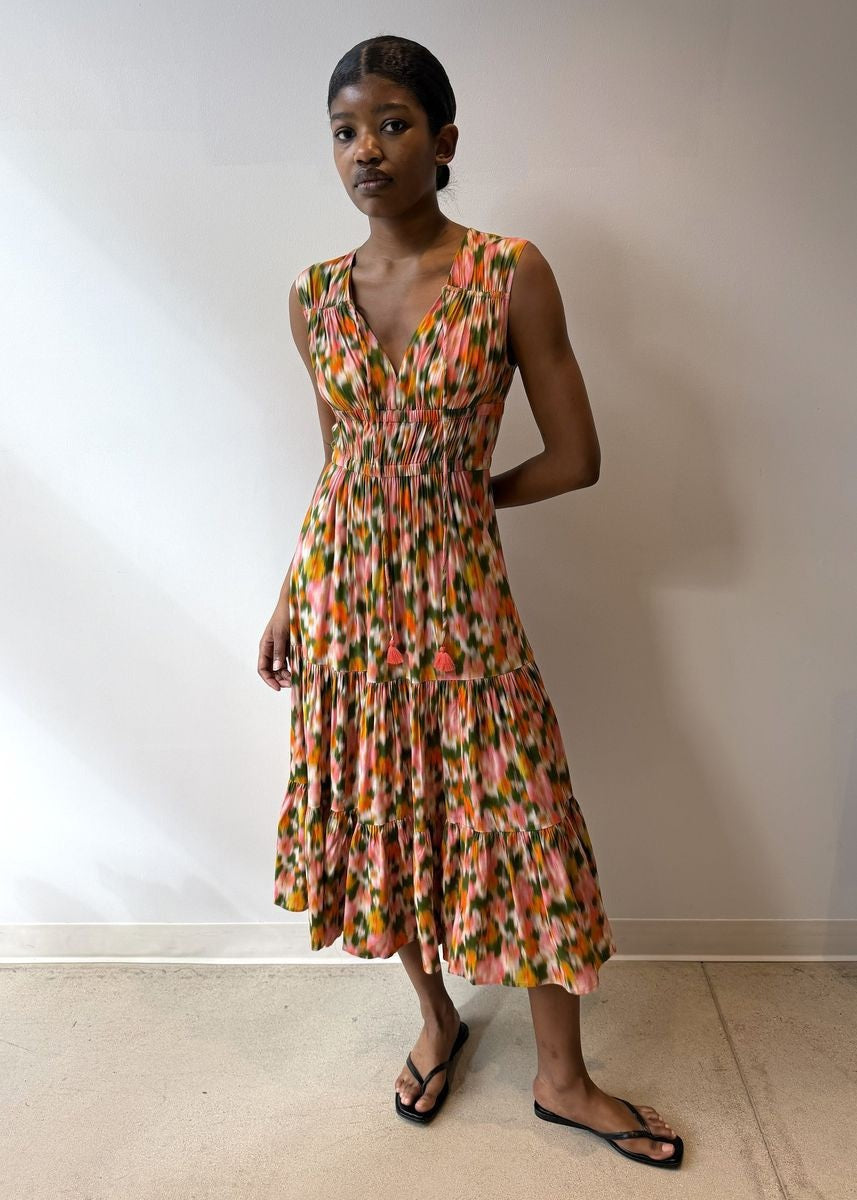 Wearing the HOPE FOR FLOWERS Tiered Peasant Maxi Dress in Garden Floral, featuring a sleeveless V-neck, shirred bodice, tiered skirt, and ruffled hem. Styled with black sandals against a plain white background.